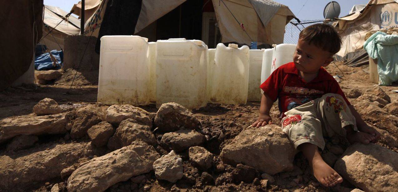 A Syrian refugee boy sits on the ground at the Domiz refugee camp in the northern Iraqi province of Dohuk
