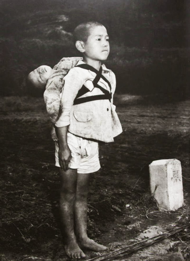 a-japanese-boy-standing-at-attention-after-having-brought-his-dead-younger-brother-to-a-cremation-pyre-1945